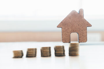 Stacks of Coins and a small house